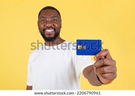 Cheerful African American Guy Showing Credit Card Recommending Bank Offer Standing Posing In Studio On Yellow Background. Money And Finances Investment Concept Royalty-Free Stock Photo #2206790961