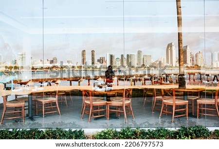 Reflection of photographer and San Diego skyline in the window of a Coronado restaurant.