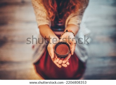 Cacao ceremony, heart opening medicine. Ceremony space. Cacao cup in woman's hand. Royalty-Free Stock Photo #2206808353