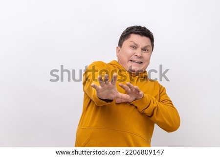 Stop. Portrait of scared man standing with afraid or worry face, looking at camera and blocking with his hands, wearing urban style hoodie. Indoor studio shot isolated on white background. Royalty-Free Stock Photo #2206809147
