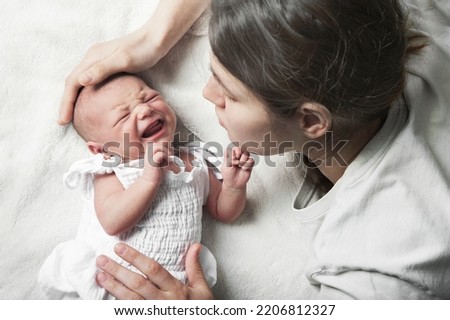 Newborn crying, sleep of children. Tired Mother with Upset Baby Suffering with Post Natal Depression. Royalty-Free Stock Photo #2206812327