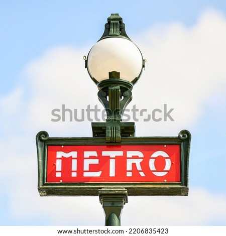 Illustration picture shows a sign with the subway logo (red symbol) in front of a parisian metro (metropolitain) station with a blue sky in the background during a summer day in Paris, France.