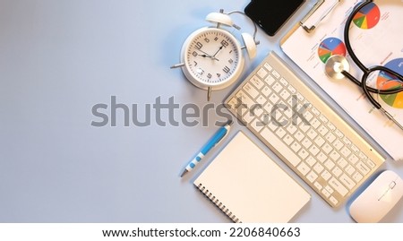 Doctor's desk with a laptop computer, medical analysis graph documents, and supplies Flat lay, top view with copy space