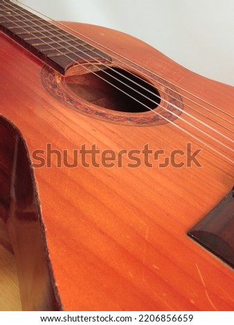 portrait of an old guitar, with its top worn from use.