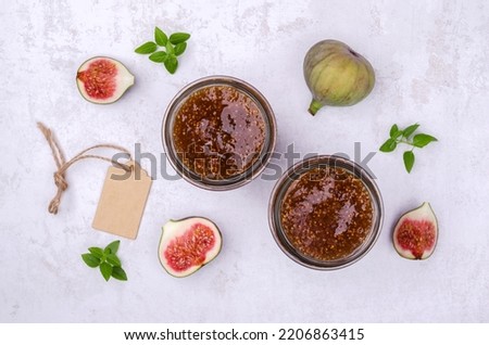 Jam figs in a glass jar on a light background. Top view. Selective focus.