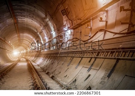 Soft focus and blurred lighting background of Underground tunnel infrastructure.Transport pipeline by Tunnel Boring Machine for electric train subway . Royalty-Free Stock Photo #2206867301