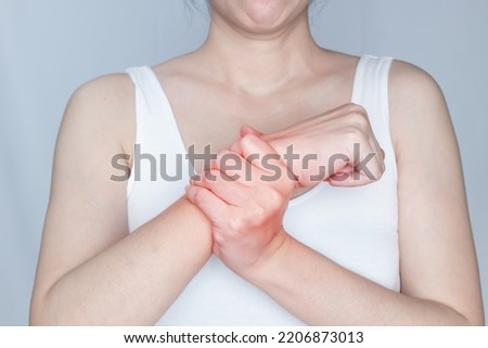 women is rubbing wrist with pain syndrome and feel numb 
