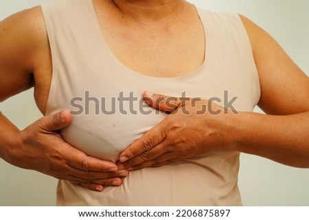 Asian woman self touching check lump or Breast cancer, Breast Self Exam. 
