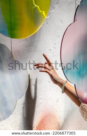 Abstract colourful cloud pattern light refraction with hand and white background. Colourful light and shadow light effect stock photo