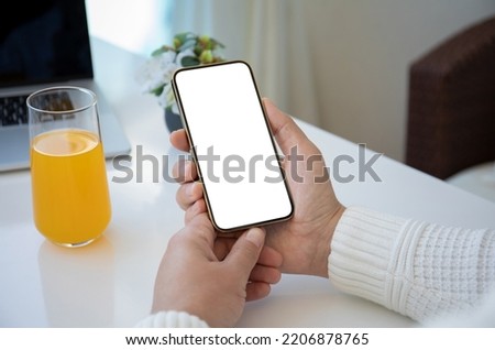 male hands hold phone with isolated screen background of table with laptop in office