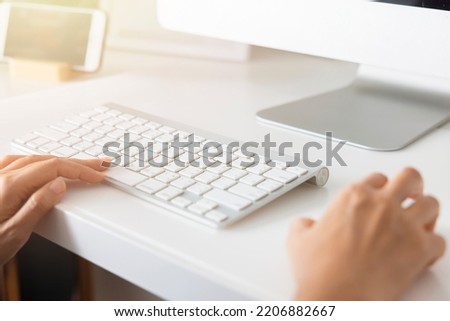 Close-up hand of Asian woman working office worker typing on keyboard at home office.