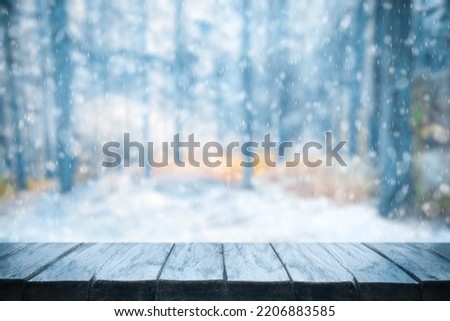 Old frozen wooden table and snowy forest. Christmas and new year winter background.