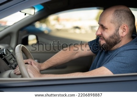 Middle-aged man driving his car, pressing horn while in a traffic jam. Car Driver Honking, close up Royalty-Free Stock Photo #2206898887