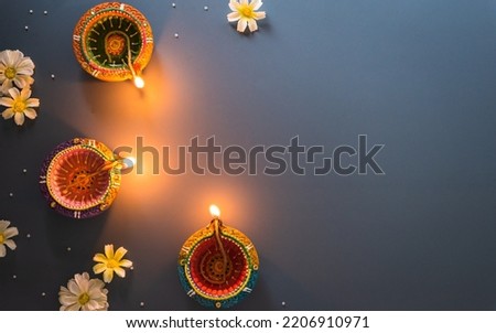 Happy Diwali - Clay Diya lamps lit during Diwali, Hindu festival of lights celebration. Colorful traditional oil lamp diya on blue background Royalty-Free Stock Photo #2206910971