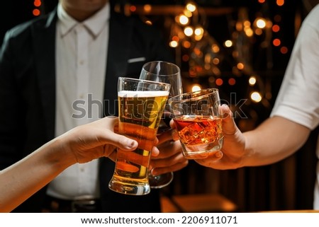 food and drink male friends are happy drinking beer and clinking glasses at a bar or pub. Royalty-Free Stock Photo #2206911071