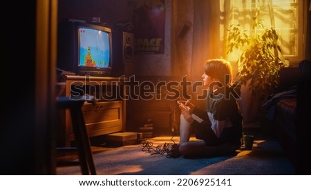 Handsome Child Playing Eight Bit Arcade Video Game on a Console at Home in His Room with Eighties Interior. Young Boy Reaches End of Level and Wins. Nostalgic Retro Childhood Concept. Royalty-Free Stock Photo #2206925141