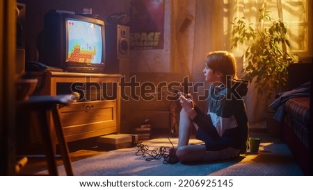 Nostalgic Retro Concept: Young Boy Playing Old-School Eighties Arcade Video Game on a Console at Home in His Room with Period-Correct Interior. Successful Kid Passes the Level and Wins. Royalty-Free Stock Photo #2206925145