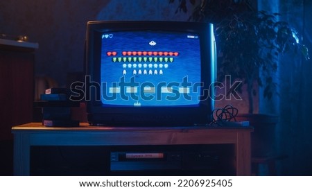 Close Up Footage of a Retro TV Set Screen with an 8 Bit 2D Eighties Inspired Console Arcade Video Game. Nostalgic Shooter Game, Player Battle with Swarm of Aliens and Wins the Level. Royalty-Free Stock Photo #2206925405