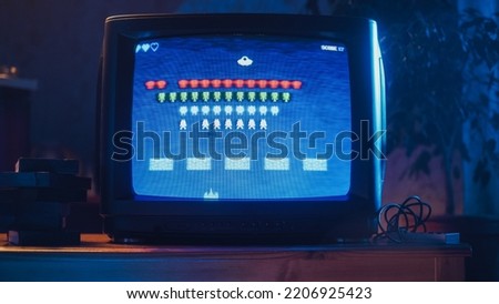 Close Up Footage of a Retro TV Set Screen with an 8 Bit 2D Eighties Inspired Console Arcade Video Game. Nostalgic Shooter Game, Player Battle with Swarm of Aliens and Wins the Hardest Level. Royalty-Free Stock Photo #2206925423
