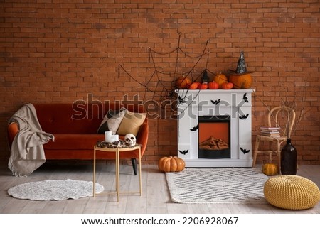 Interior of living room decorated for Halloween with fireplace, sofa and chair