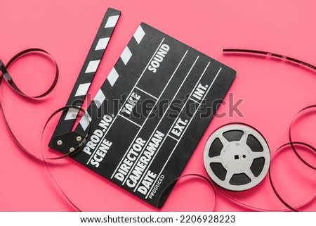 Movie clapper with reel on pink background