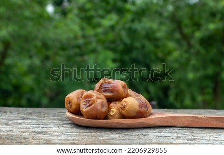 Phoenix Dactylifera or  Date Palm Fruit in Wooden Ladle Isolated on Wooden Background with Copy Space Royalty-Free Stock Photo #2206929855
