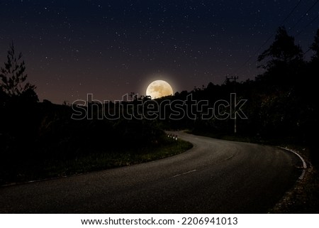 Night landscape with empty highway in forest full moon rising over the horizon and stars