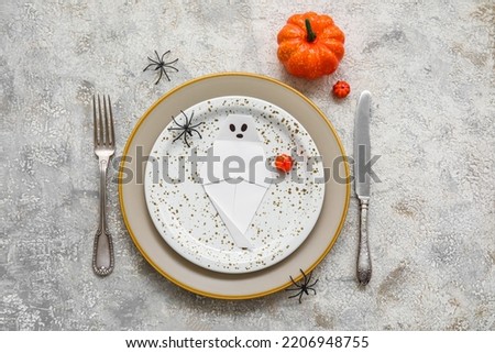 Table setting for Halloween celebration on light background