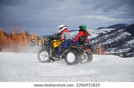 Portrait of man and woman riding on offroad four-wheeler ATV. Concept of active leisure and winter activities. Royalty-Free Stock Photo #2206955829