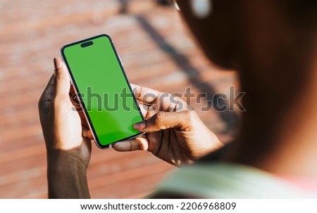 Sportive woman using her phone in a park Royalty-Free Stock Photo #2206968809