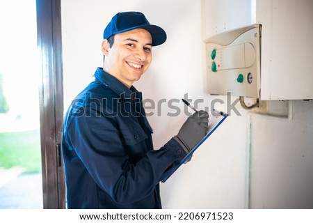 Technician servicing an hot-water heater Royalty-Free Stock Photo #2206971523