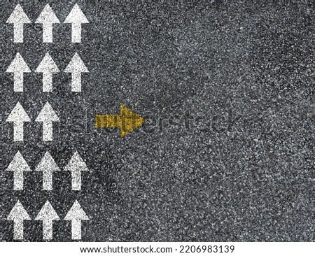 Different thinking and Business and technology disruption concept. Yellow big arrow opposite direction with white arrow on road asphalt.