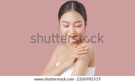 Close up perfect beauty face of young beautiful Asian woman applying moisturizer cream on her shoulder and arm gently.