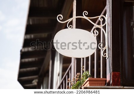 Horizontal front view of empty round metal signage on a building with classical architecture