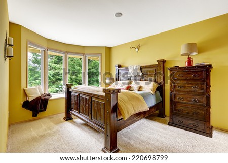 Farm house interior. Luxury bedroom interior. Beautiful wooden high bed with large dresser