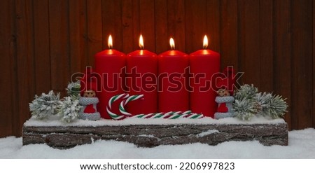 Dekoration zum vierten Advent oder Weihnachten.Vier rote brennende Kerzen mit weihnachtsschmuck.