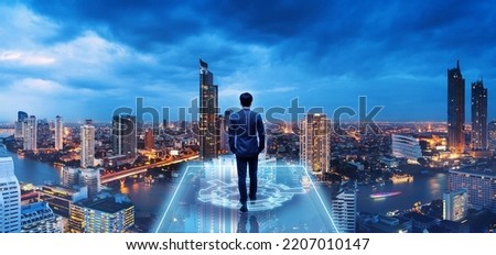 Business technology concept, Professional business man walking on future Bangkok city background and futuristic interface graphic at night, Cyberpunk color style