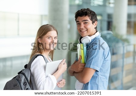 Portrait of students couple smiling and looking at camera.
