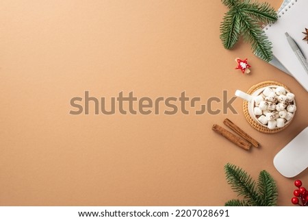 New Year concept. Top view photo of big cup of hot drinking with marshmallow on serving mat planner computer mouse cinnamon sticks fir branches mistletoe on isolated beige background with copyspace