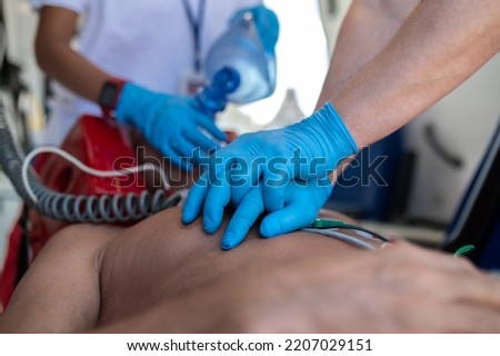 Paramedical staff performing the heart massage and oxygenation procedure