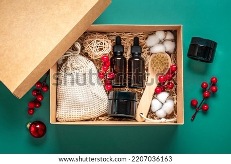 Set for Christmas care box Eco-friendly cosmetics Oil and cream bottles, brush for washing, cotton pads on green background Gift for girlfriend, mother to celebrate Christmas concept Top view Flat lay Royalty-Free Stock Photo #2207036163