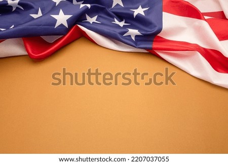 Top view of the American flag on a brown background with copy space for text. Close-up photo