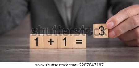 1+1=3 on wooden cubes. Synergy  Royalty-Free Stock Photo #2207047187