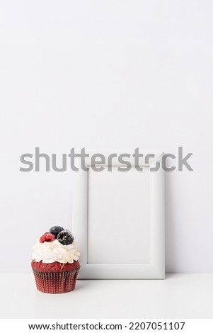 Art photo frame mockup with cup of coffee and cupcake, white background template