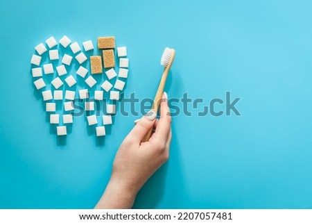 Flat lay, tooth made of sugar on a blue background.