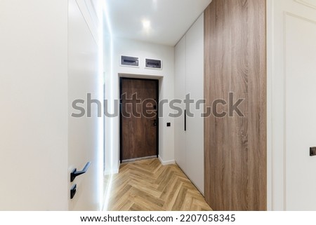 interior design of a new house, a bright corridor with a mirror and a closet