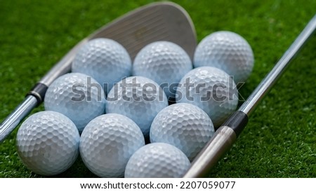 Golf club and ball in grass concept. Golf balls on the golf course with golf clubs. In the morning, with the beautiful sunlight.                                