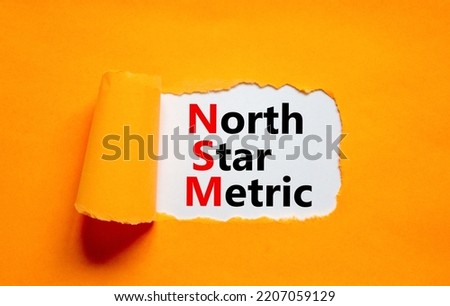 NSM north star metric symbol. Concept words NSM north star metric on white paper on a beautiful orange background. Business and NSM north star metric concept. Copy space.