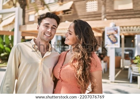 Man and woman couple smiling confident and hugging each other at street