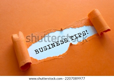 BUSINESS TIPS word written under torn paper.